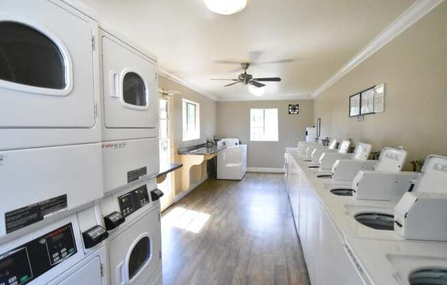 a laundry room with white washers and dryers