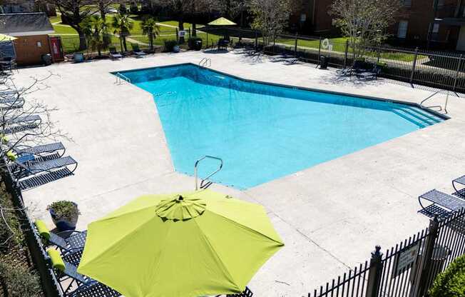 A pool with a yellow umbrella in the foreground.