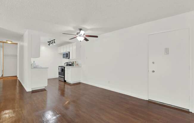 an empty living room with a ceiling fan and a kitchen at Camino de Oro Apartments, Torrance, CA, 90505