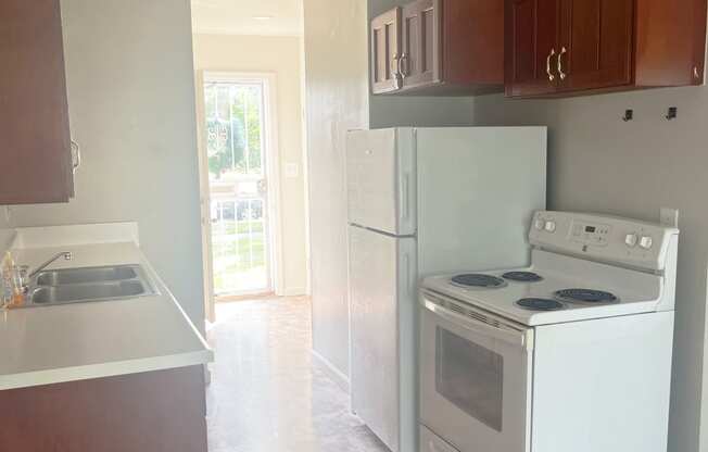 A kitchen with white appliances and wooden cabinets