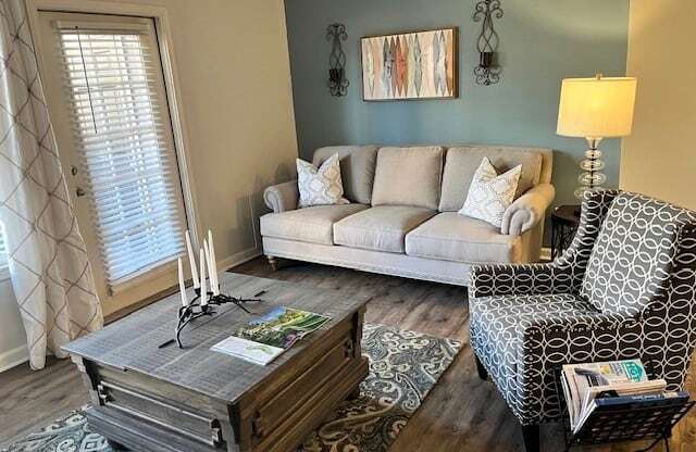 A living room with a grey couch, a patterned chair, and a coffee table.