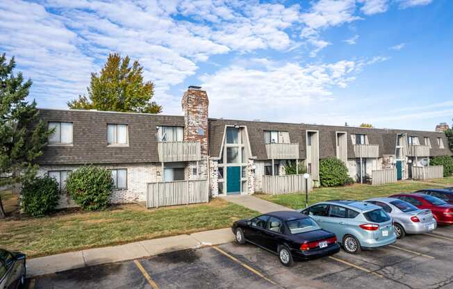 a parking lot with cars in front of an apartment building