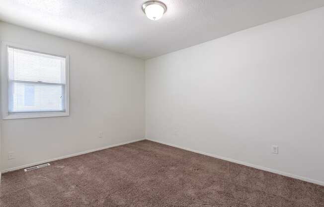 A room with a window and carpeted floor at Spring Creek Townhomes Apartments, Springfield, IL