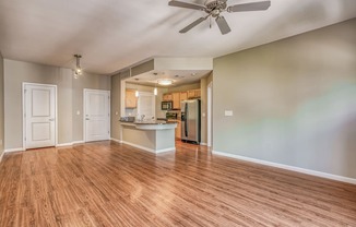 A living and kitchen area with a ceiling fan and hardwood floors at The District, Denver, CO
