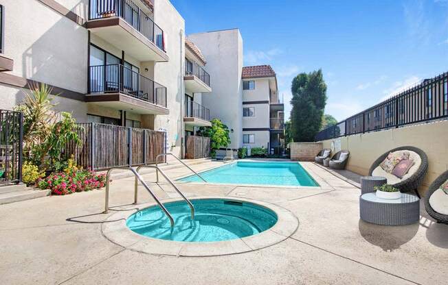 a swimming pool with a hot tub in front of an apartment building  at Sherway Villa, Reseda, 91335