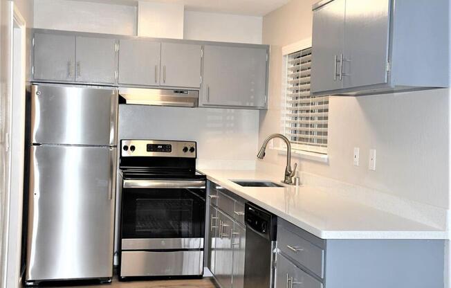 a kitchen with stainless steel appliances and white counter tops