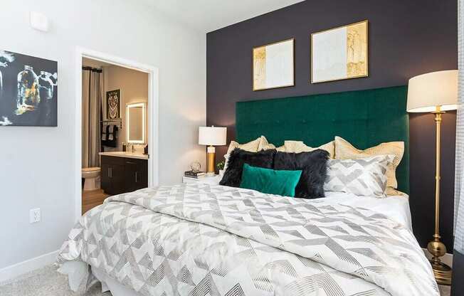 A bed with a white comforter and a black and white pillow is in the center of the image.