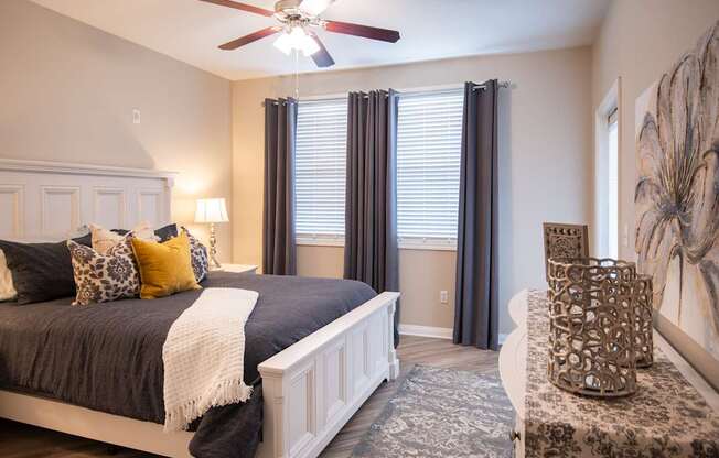 A bedroom with a large bed and a ceiling fan.