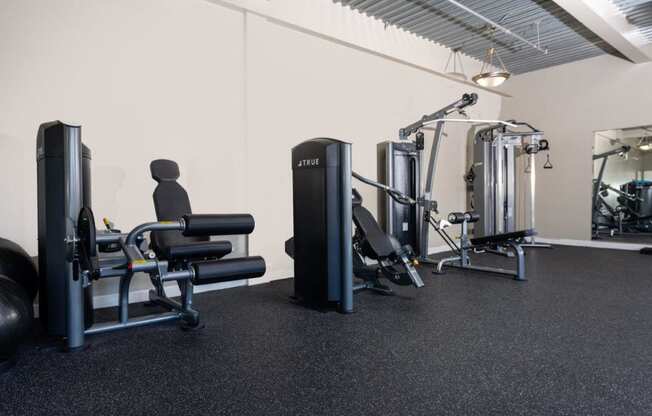 a gym with weights and other equipment in a room with white walls