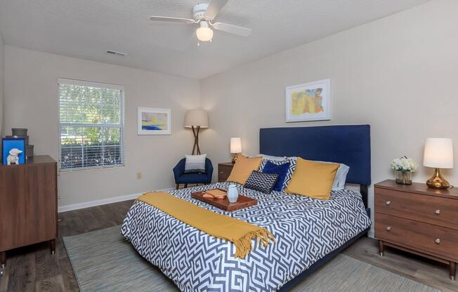 Bedroom with a bed and ceiling fan at Ashley Oaks Apartments in Greensboro, North Carolina