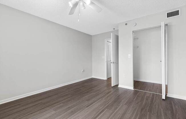 A room with a ceiling fan and a sliding door.