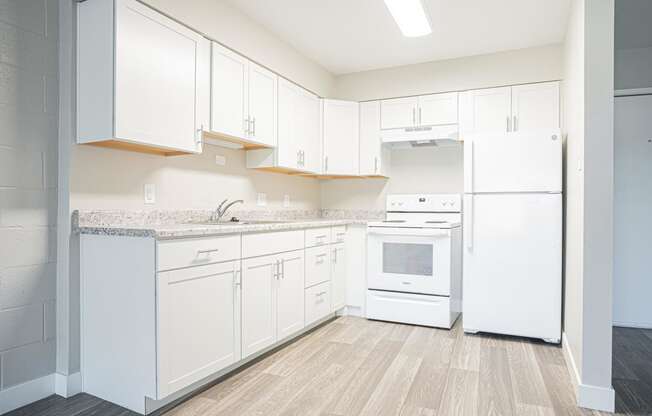 a white kitchen with white appliances and white cabinets