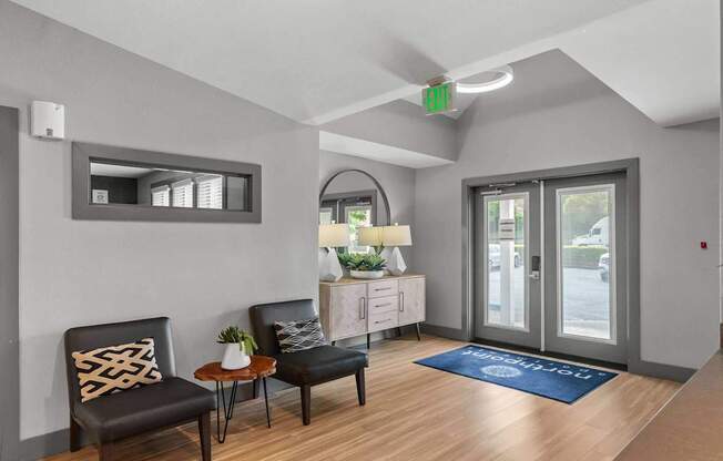 A waiting area with two black chairs and a wooden table. at Northpoint Apartments, Washington