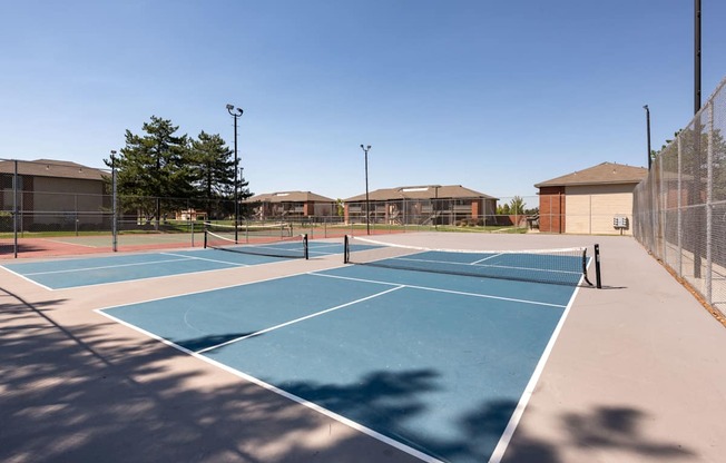 two tennis courts at the whispering winds apartments in pearland