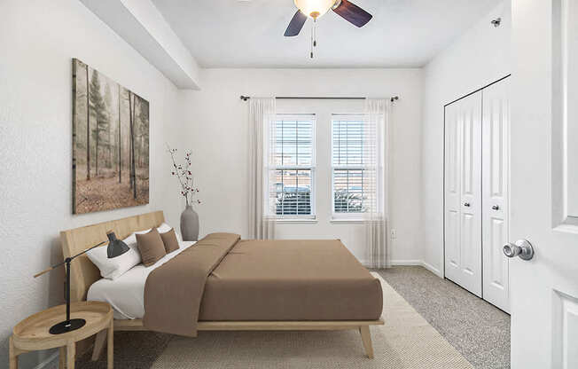 A bedroom with large windows and a ceiling fan at Lynbrook Apartments and Townhomes, Elkhorn, NE, 68022