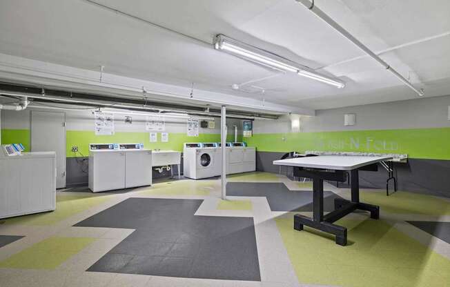 a large laundry room with washing machines and a table