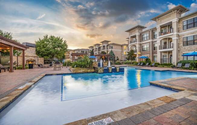 a large swimming pool with an apartment building in the background