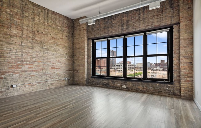 an empty room with a large window and brick wallsat Gaar Scott Historic Lofts, Minnesota