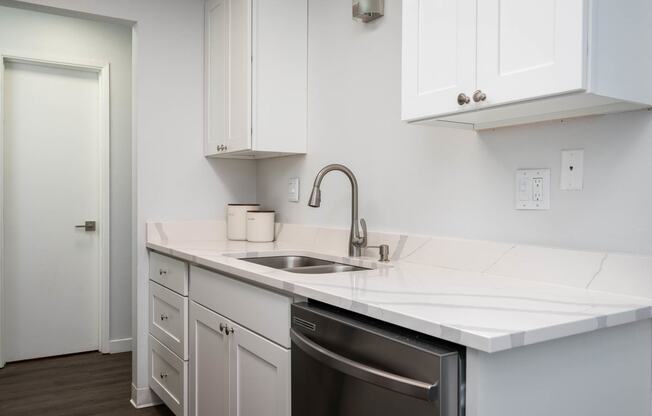 a kitchen with white counter tops and a sink