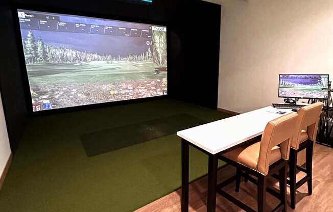 a room with a table and chairs and a large screen