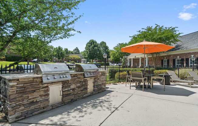 A picnic area with a stone wall and a grill.