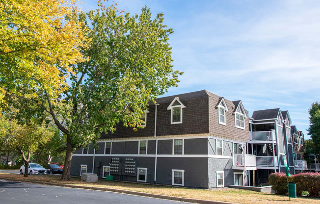 a large apartment complex with a tree in front of it