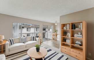 A living room with a white couch and a wooden bookshelf.