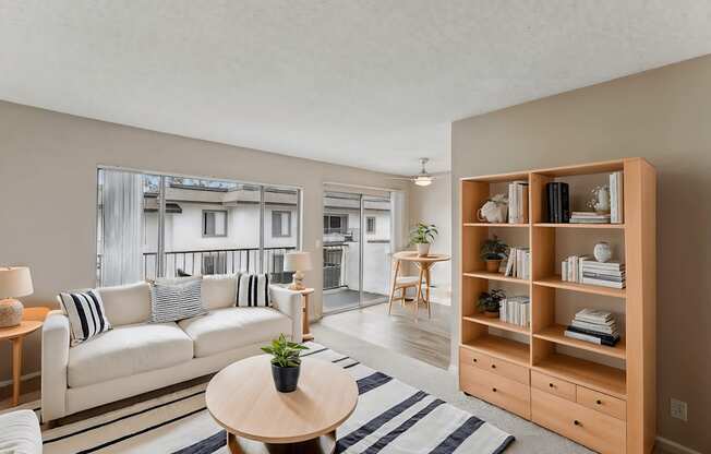 A living room with a white couch and a wooden bookshelf.