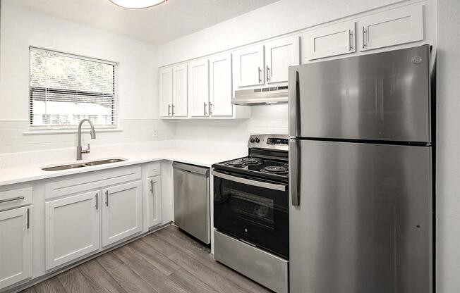 a kitchen with stainless steel appliances and white cabinets