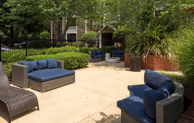 a patio with couches and chairs in a garden