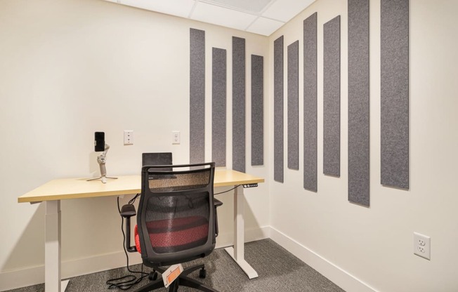 a room with a desk and a chair and a wall of stripes on the wall