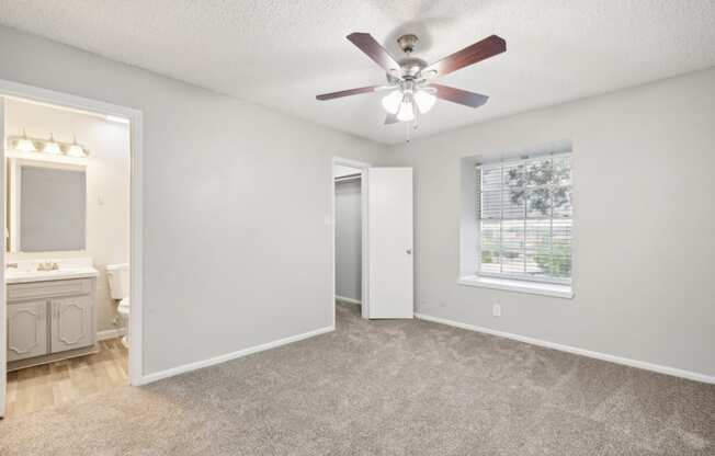 a bedroom with a ceiling fan and a window