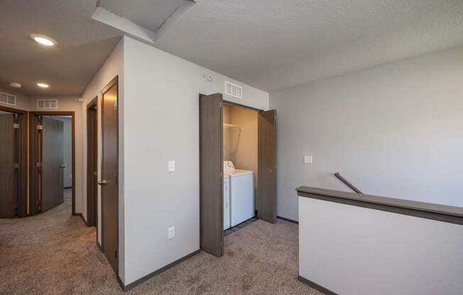 A room with a white wall and a brown carpet.