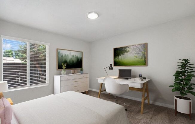 a bedroom with a bed and a desk with a laptop