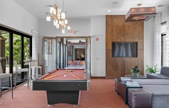 a living room with a pool table and a tv