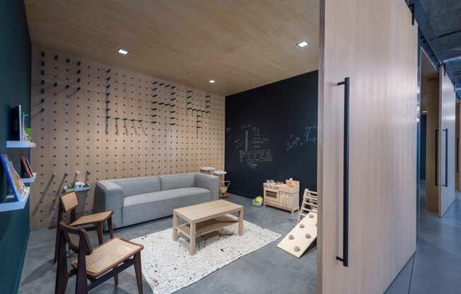 a living room with a couch and tables and a chalkboard