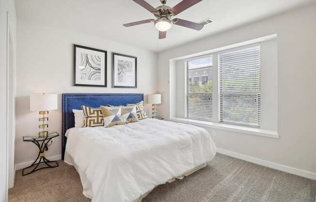 a bedroom with a bed and a ceiling fan