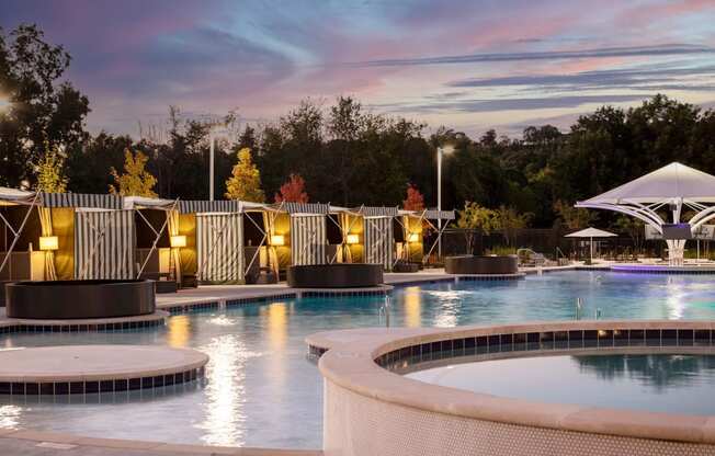 a swimming pool at night with a sunset in the background at Esplanade District Apartments, Little Rock, AR,72114