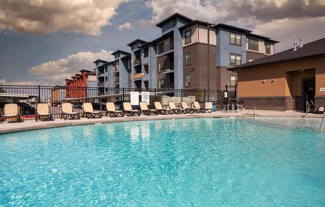 A swimming pool in front of a multi-story apartment building.