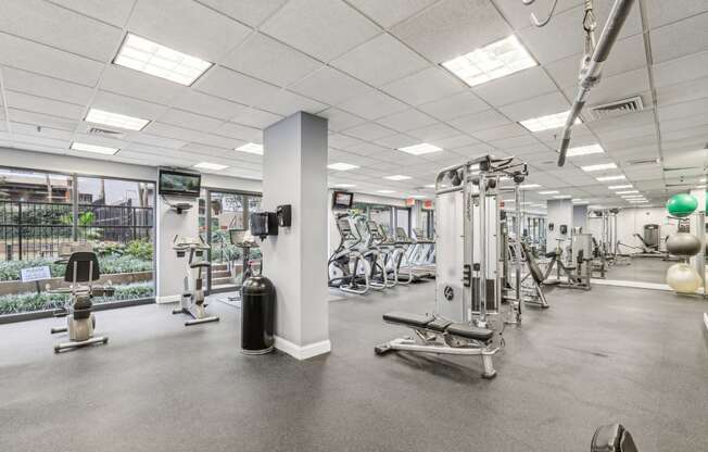 a gym with weights and other exercise equipment in a building with glass doors