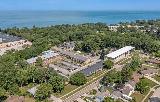 an aerial view of the campus with the ocean in the background