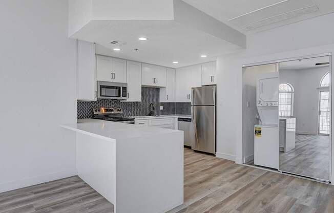 A modern kitchen with stainless steel appliances and white cabinetry.