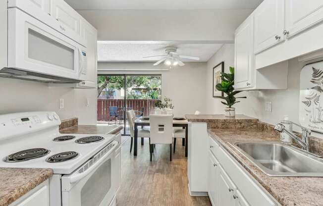 a kitchen with white appliances and granite counter tops at Summerwood Apartments, California