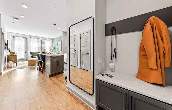 A modern kitchen with a wooden floor and a large mirror on the wall