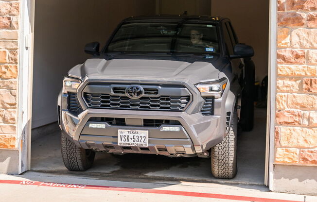 A grey Toyota 4x4 is parked in a garage.