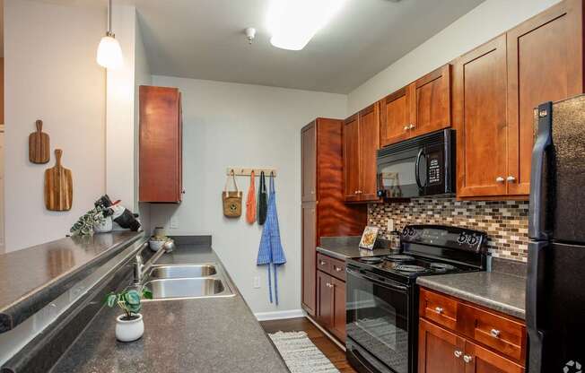 A kitchen with wooden cabinets and black appliances.