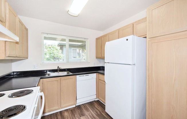 a kitchen with white appliances and wooden cabinets