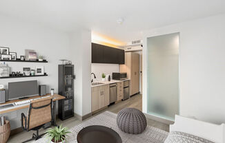 Model living and kitchen areas with office desk