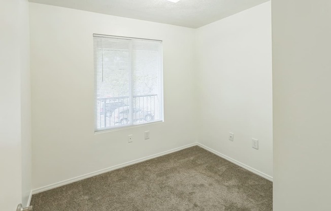 an empty room with carpet and a window