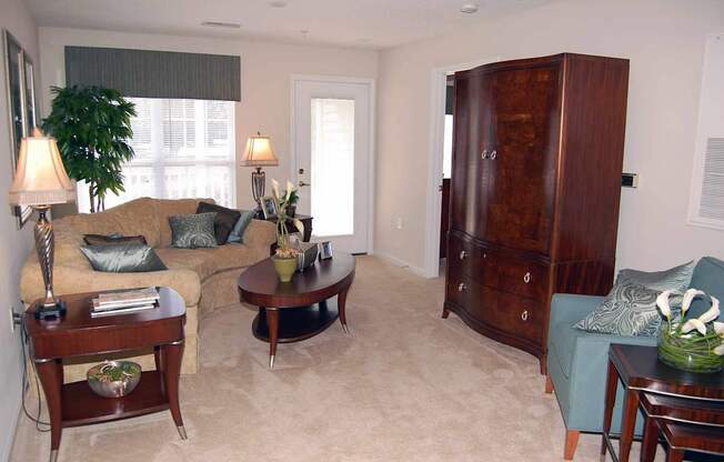 A living room with a couch, a coffee table, and a lamp.